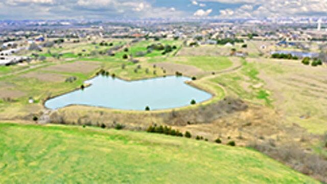 Aerial of open land with Texas-shaped lake