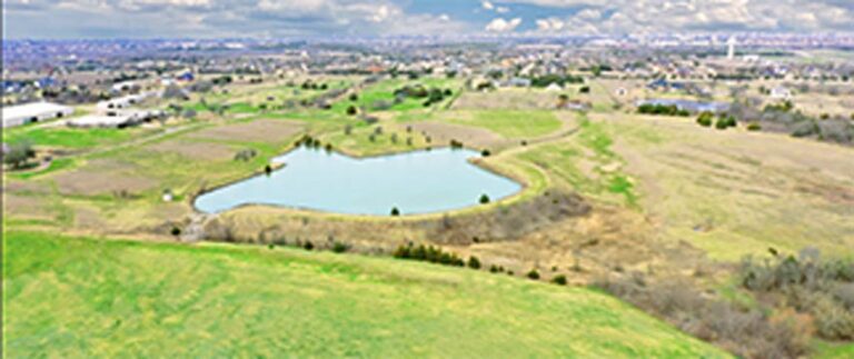 Aerial of open land with Texas-shaped lake